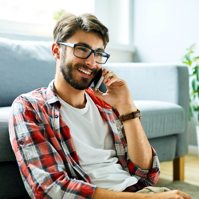 A smiling man talking to someone on his cell phone.
