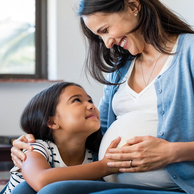 A pregnant mother with her daughter.