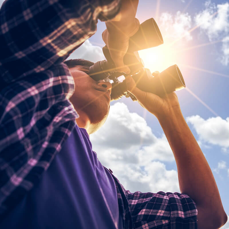 A man looking through binoculars