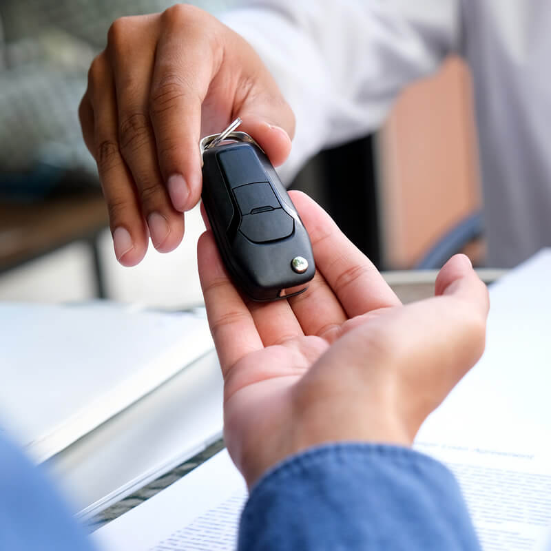 A person being handed a car key.