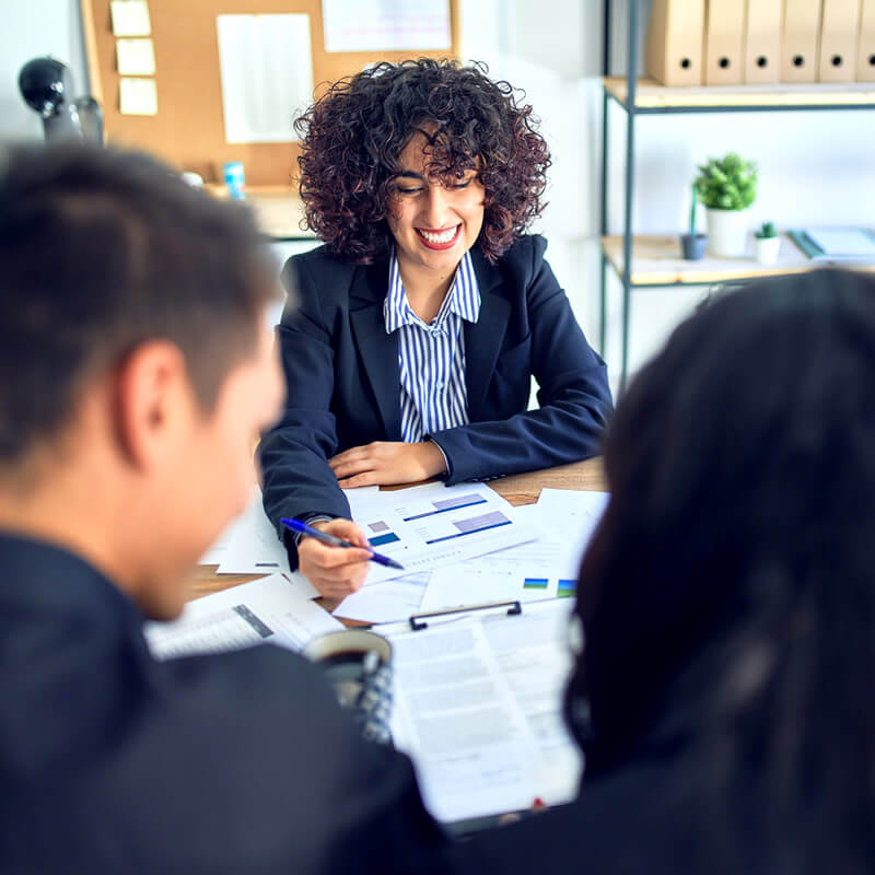A couple meet with a financial planner in her office.