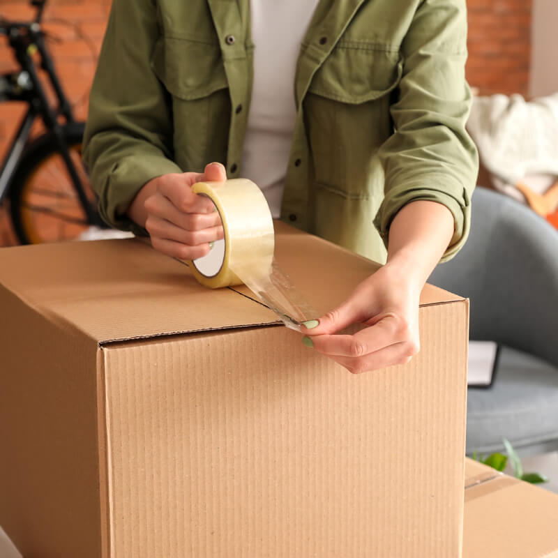 A person packing a moving box.