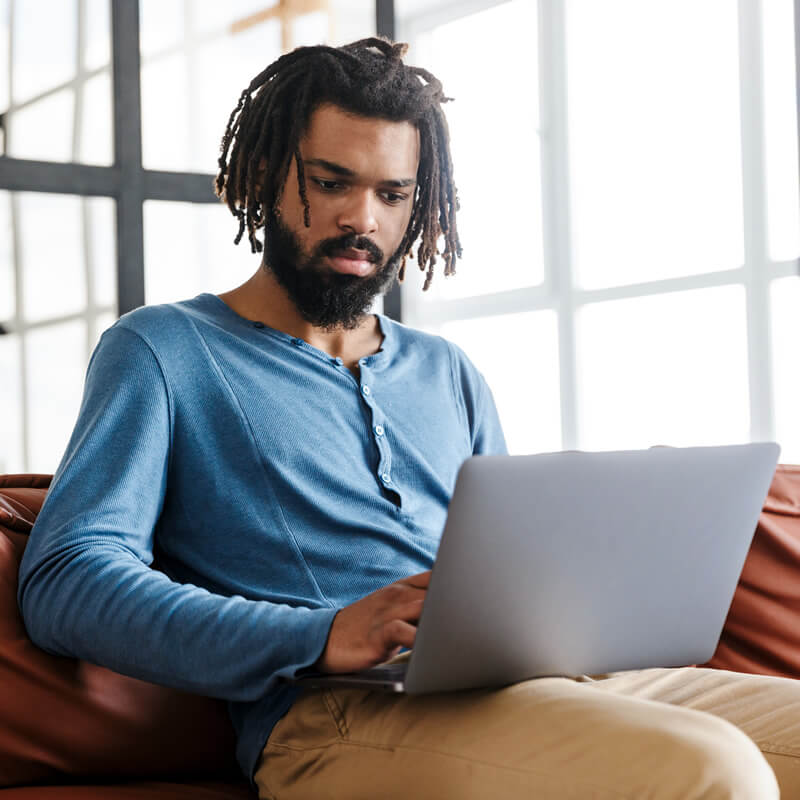 A focused man using a laptop computer.