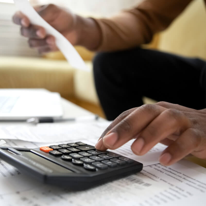 A person entering receipt figures into a calculator.