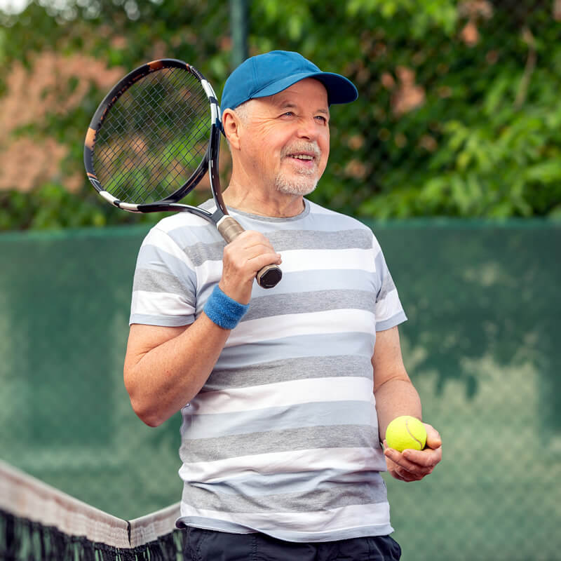 A retired man plays tennis