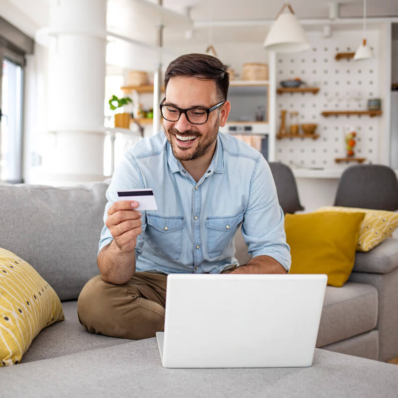 A happy man holding a credit card.