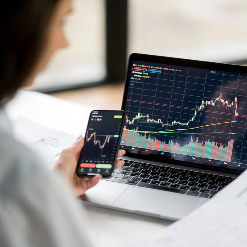 A woman looking at stock charts on her laptop