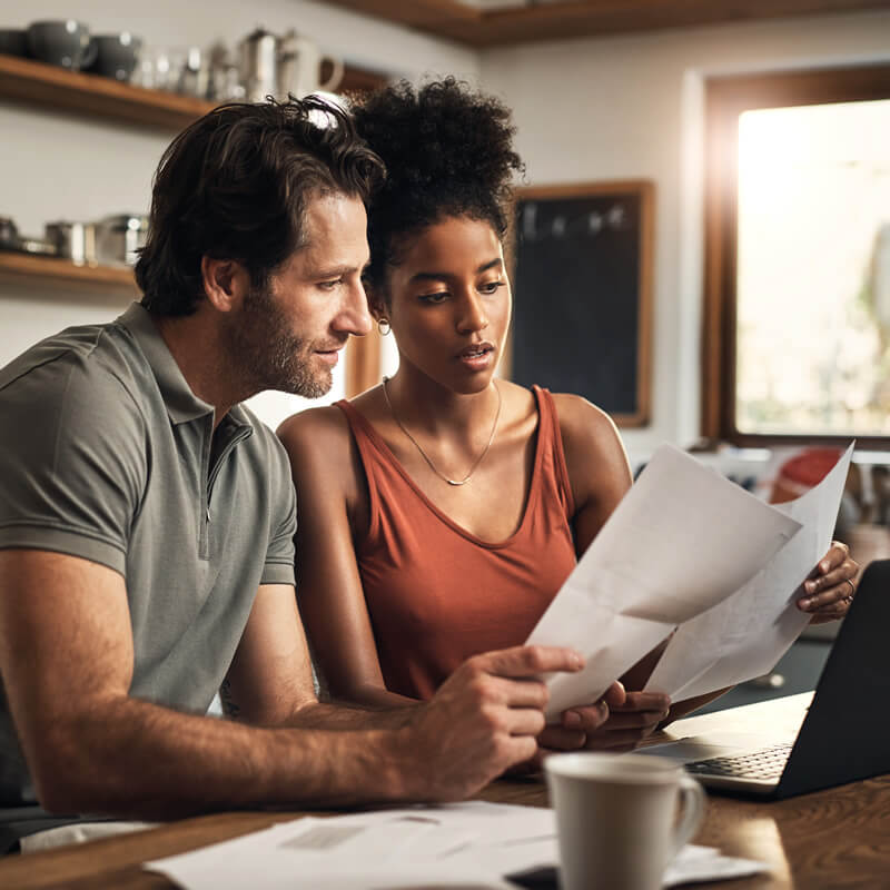 A couple in the kitchen reviewing their spending.