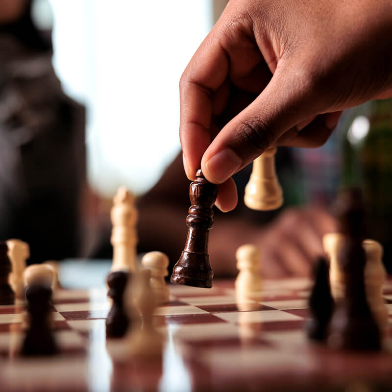 A person moving a piece on a chess board.