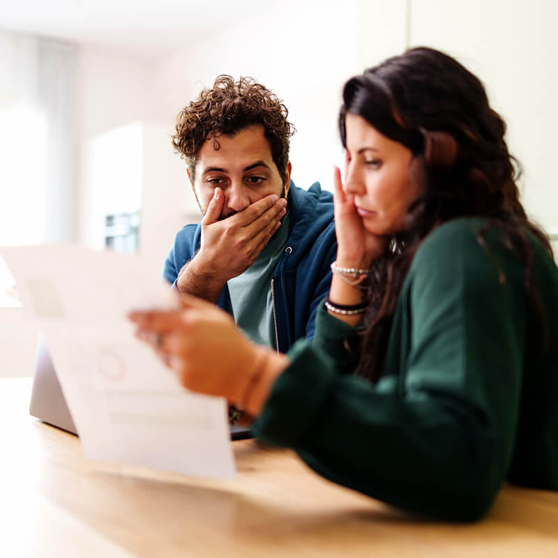 A worried couple reviewing a bill.