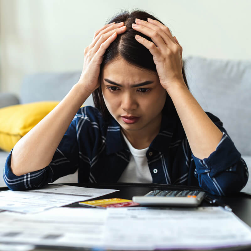 A worried woman looking at her bills.