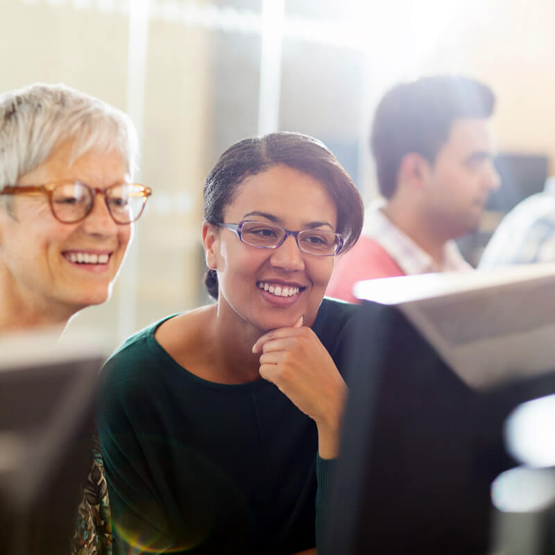 A teacher and student look at a computer screen