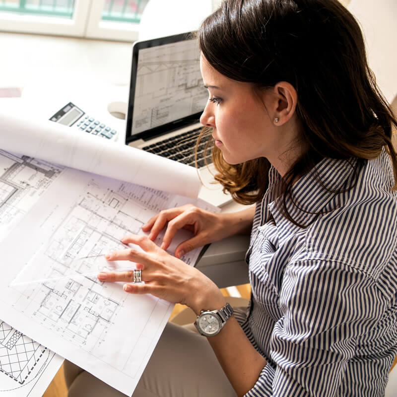A woman reviews an architectural drawing.