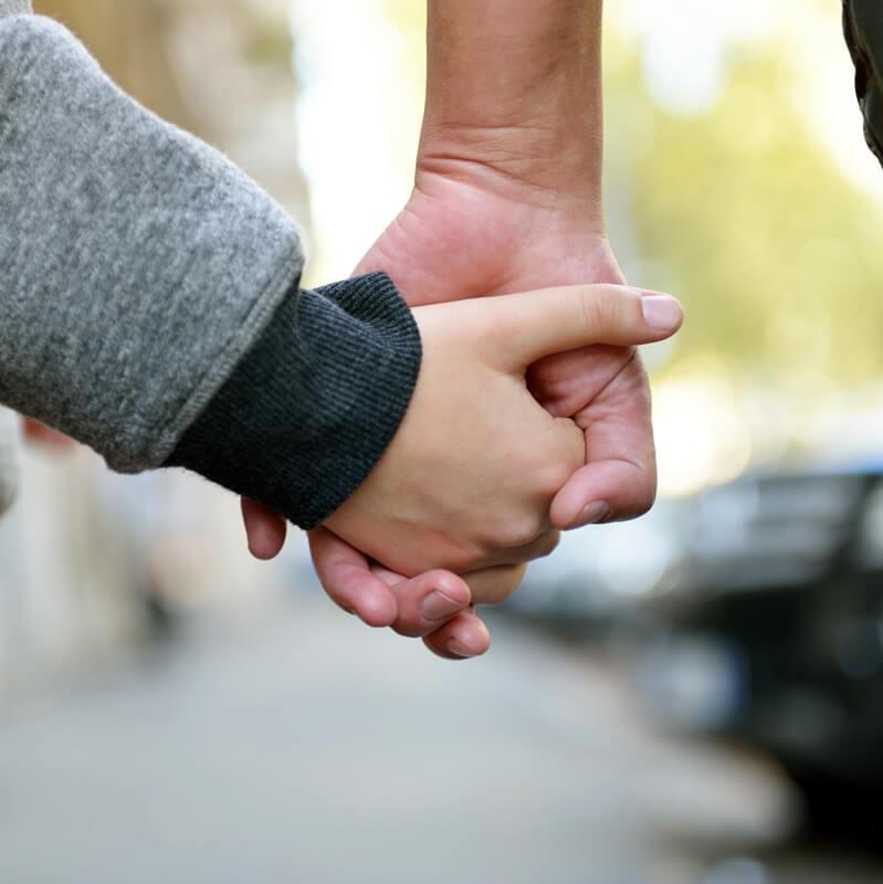 A parent and child hold hands