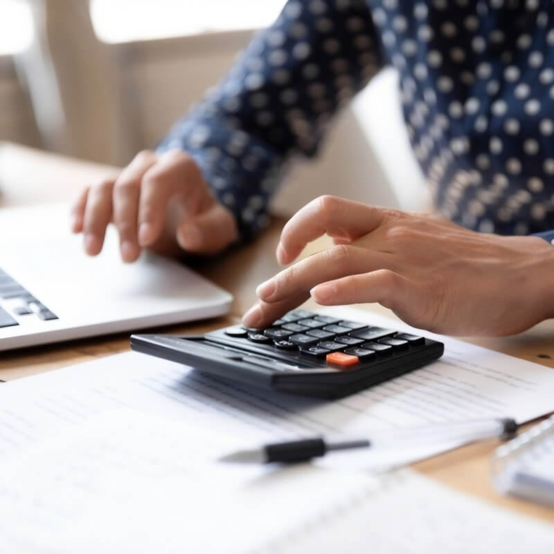 A person using a calculator and computer