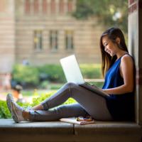 A student studies outside on a college campus