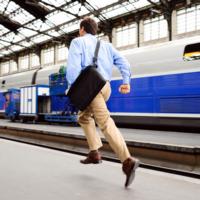 A man rushing to catch up with a train.