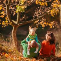 A father, mother, and young child play outside