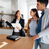 A real estate agent shows a couple a home