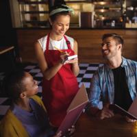 A waitress takes an order from a couple.