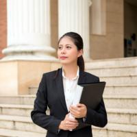 A young lawyer on the steps of a courthouse.