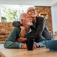 A retired couple smiles in their home