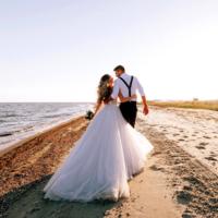 A bride and groom on the beach.