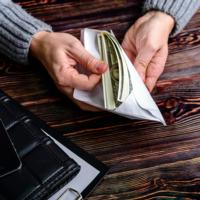 A man opens an envelope full of money