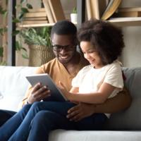 A father reading with his daughter at home.
