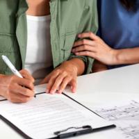 A couple signs a purchase agreement for a new home.