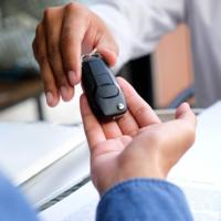 A person being handed a car key.