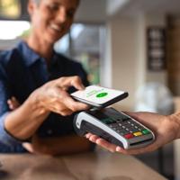 A person makes a purchase using a smart phone.