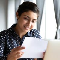 A pleased woman reviews a financial document.