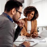 A financial services worker explains options to a customer.