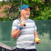 A retired man plays tennis
