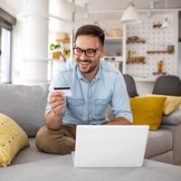 A happy man holding a credit card.