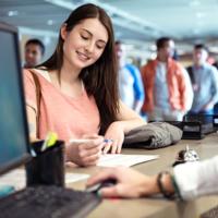 A college student signs a financial aid document at school.