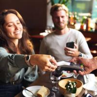 A woman pays for dinner at a restaurant.