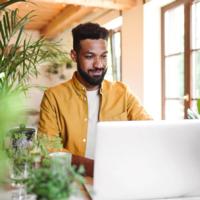 A man uses a laptop at home