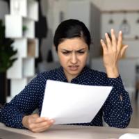 An exasperated woman reviewing a document.