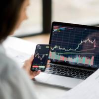 A woman looking at stock charts on her laptop
