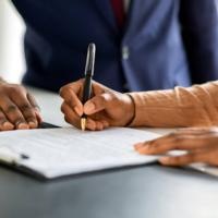 A person signs a legal document.