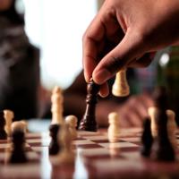 A person moving a piece on a chess board.
