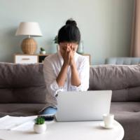 A distraught woman sitting on her sofa.