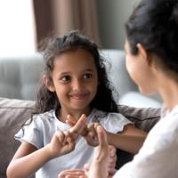 A mother and daughter use sign language