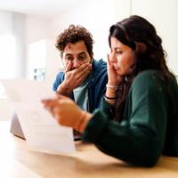 A worried couple reviewing a bill.
