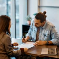 A man signs an agreement for a loan.