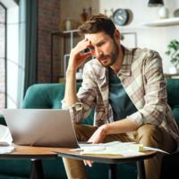 A troubled man reviewing bills.