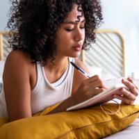 A young woman writes an entry in her diary.