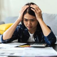 A worried woman looking at her bills.